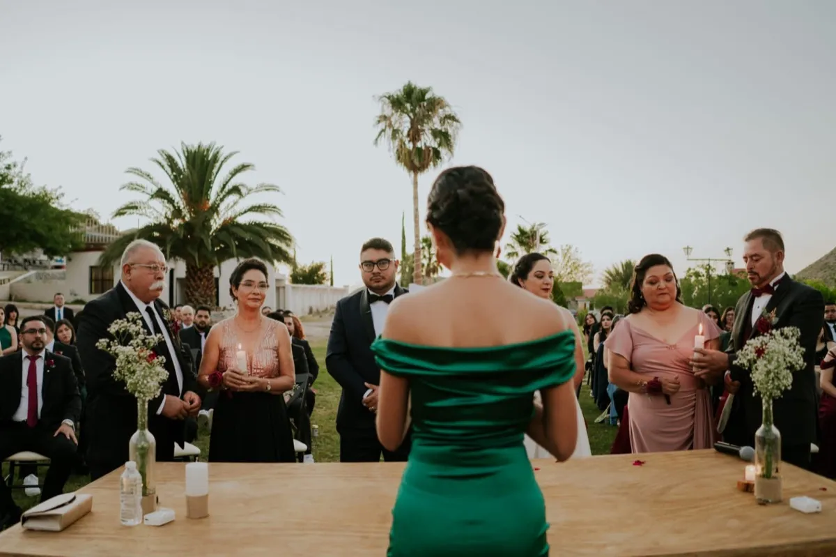 Guía espiritual dirigiendo ceremonia con la familia participando con velas