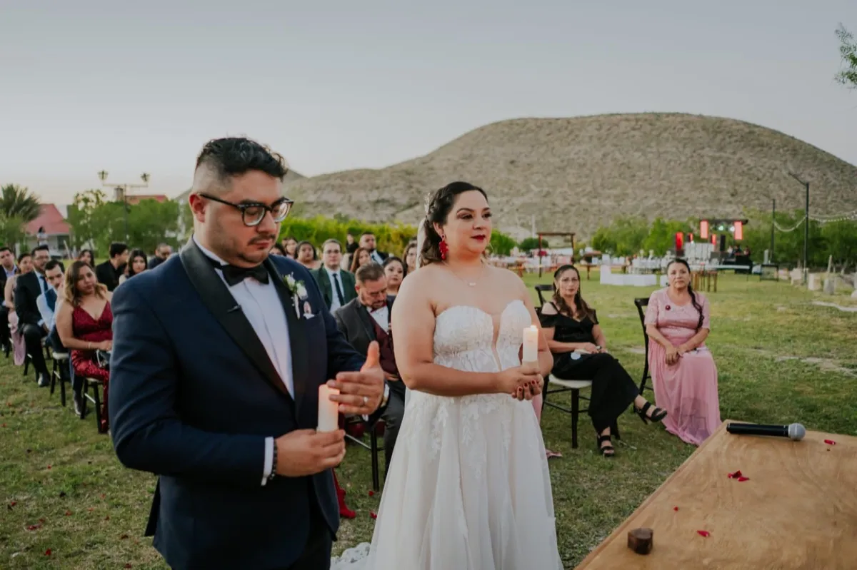 Pareja sosteniendo velas durante ceremonia de la luz al atardecer